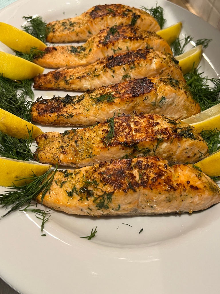 Buttery dill salmon served with lemon wedges​