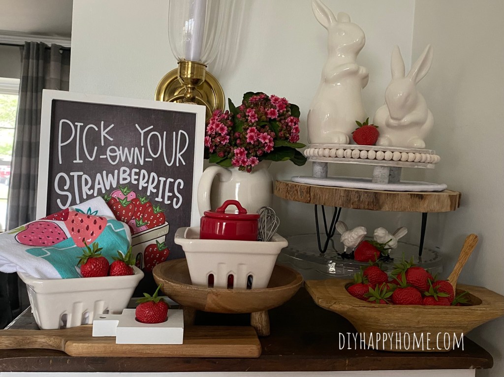 Fun spring decor featuring bunnies, strawberries, and birds, using some items from the target dollar spot, Rae Dunn ceramics, faux flowers, and some natural wood pieces from Hobby Lobby.​